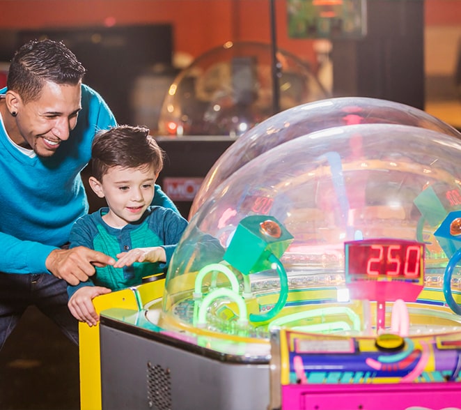 father son playing amusement arcade